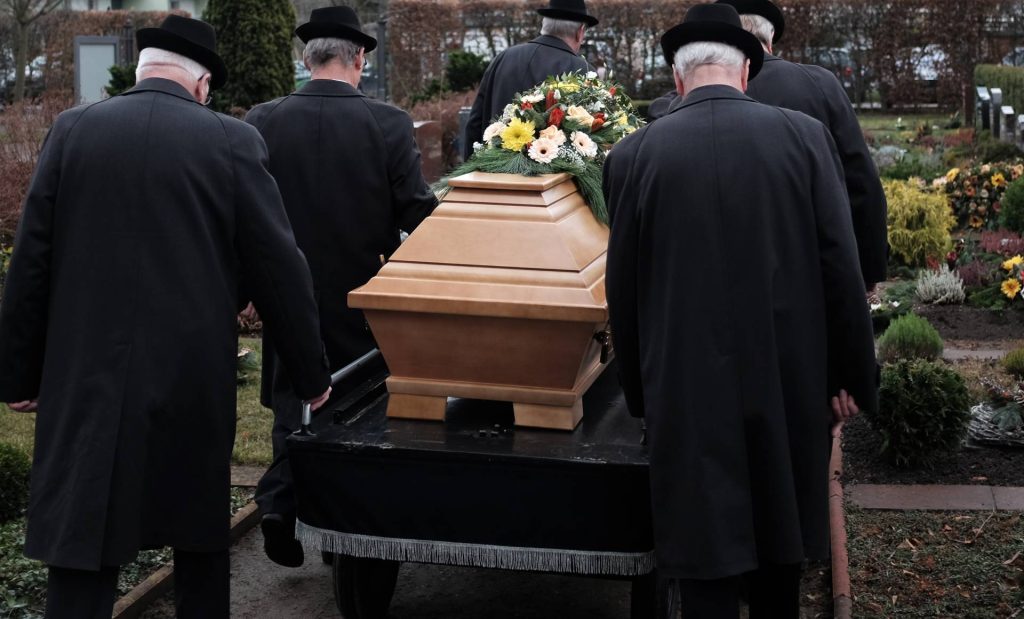 Enterrement avec cercueil et fleurs